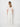 Woman wearing a white outfit against a plain background
